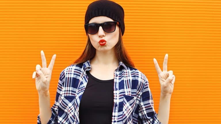 Jeune femme en lunettes de soleil qui fait le signe de la paix